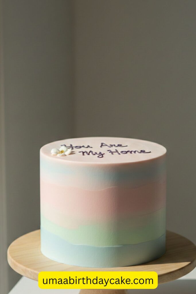 Minimalist pastel birthday cake with handwritten message “You Are My Home”, clean buttercream finish, simple modern design, soft neutral background, emotional aesthetic, natural window lighting